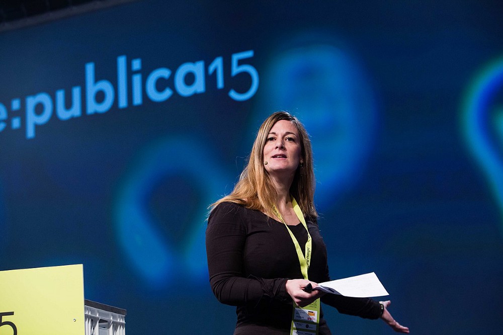 Woman speaking at a conference holding papers in her hand